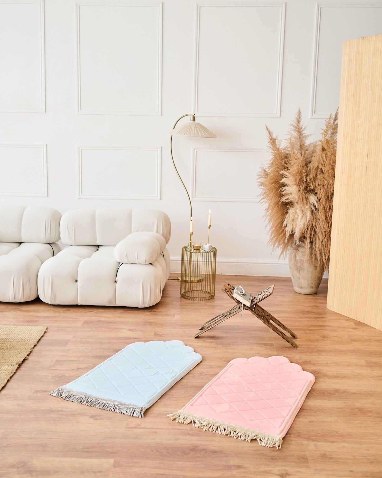 Two colorful rugs on a wooden floor with a white wall and decorative items in the background.