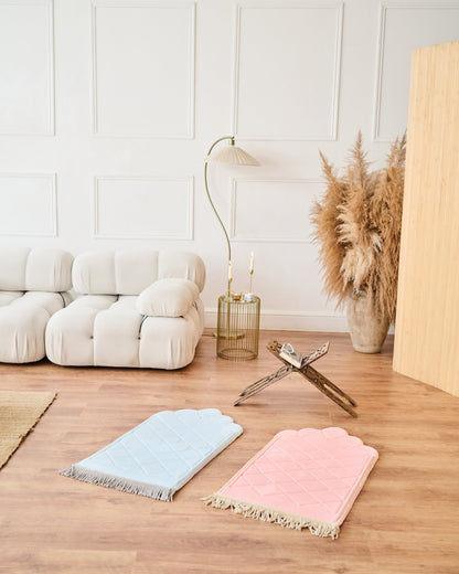Two colorful rugs on a wooden floor with a white wall and decorative items in the background.