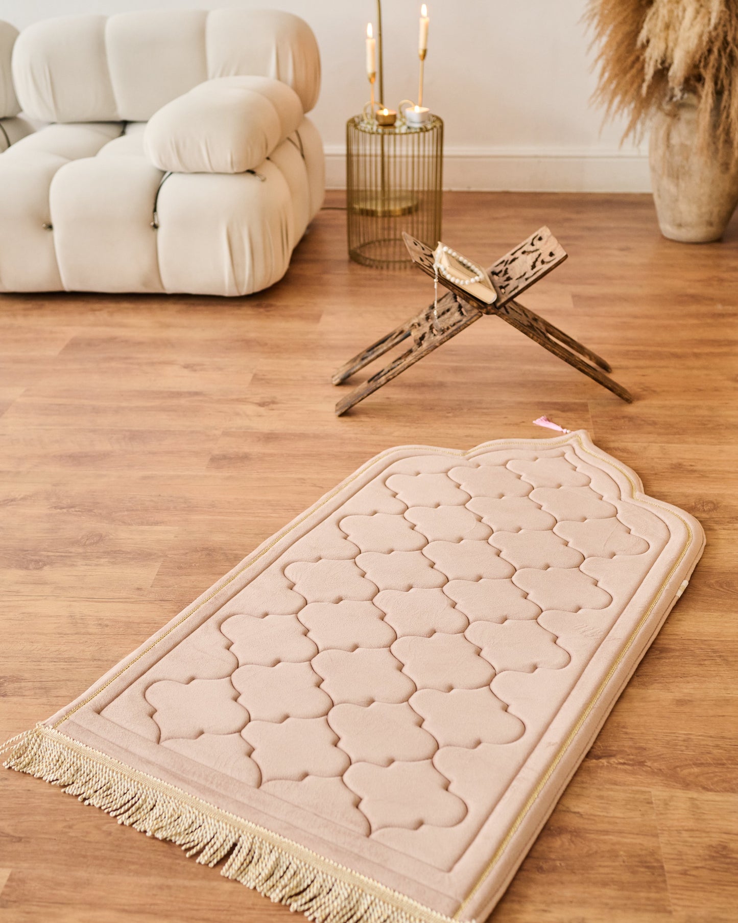 Beige patterned rug on a wooden floor with a white sofa and decorative items in the background.