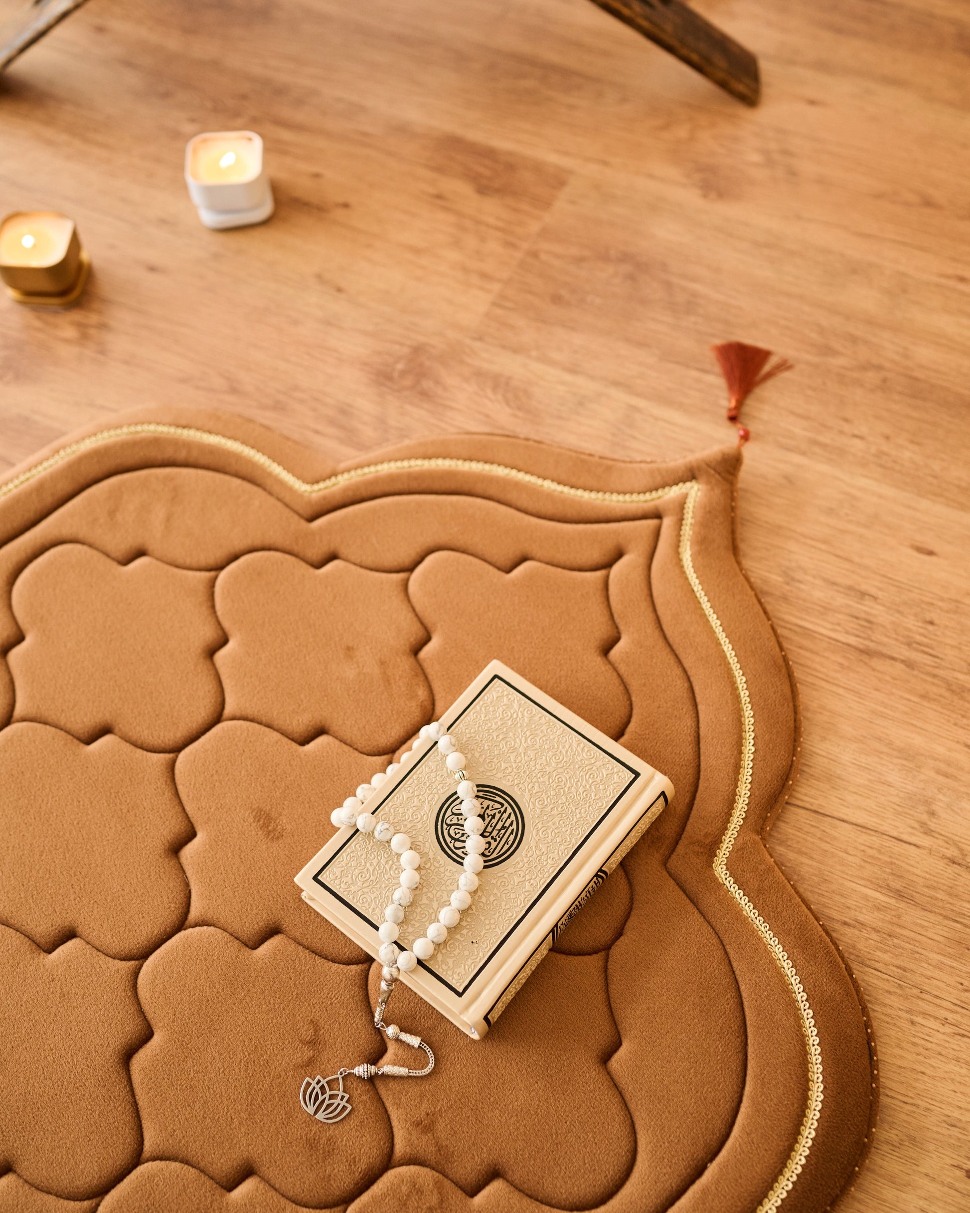 luxury thick padded foam prayer mat with a rosary, candles and Quran